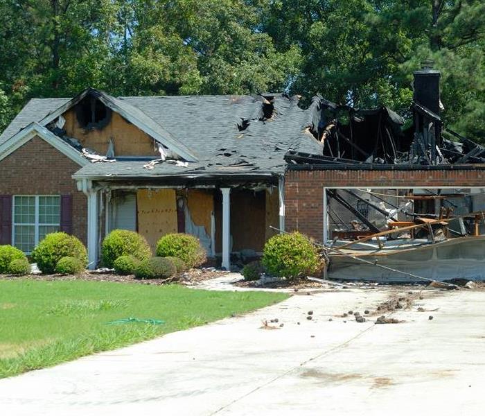 A home with fire damage and boarded areas. 