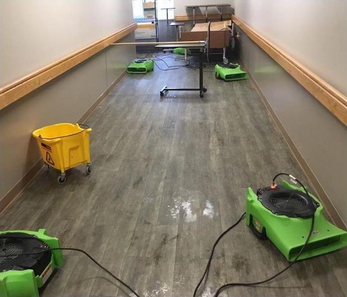 Hallway with water damage and SERVPRO equipment setup